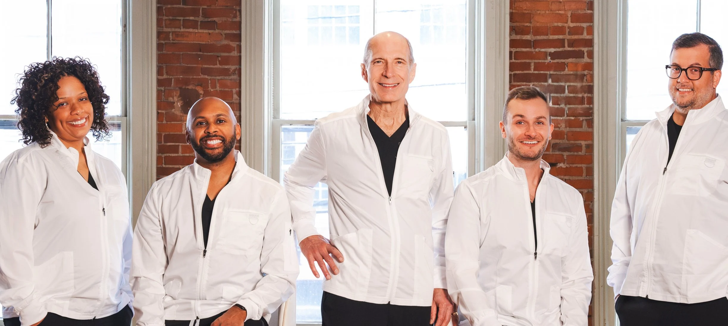 Smiling medical team in white coats.