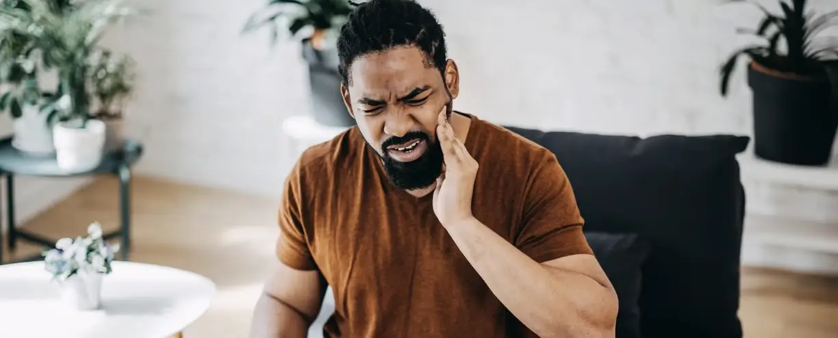 man-at-home-with-a-toothache-YanyBBXz1kuEBbjm Man experiencing severe toothache pain.