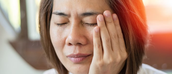 tmj-pain-AwvMrjWeWPCJrrMW Woman experiencing facial pain or discomfort.